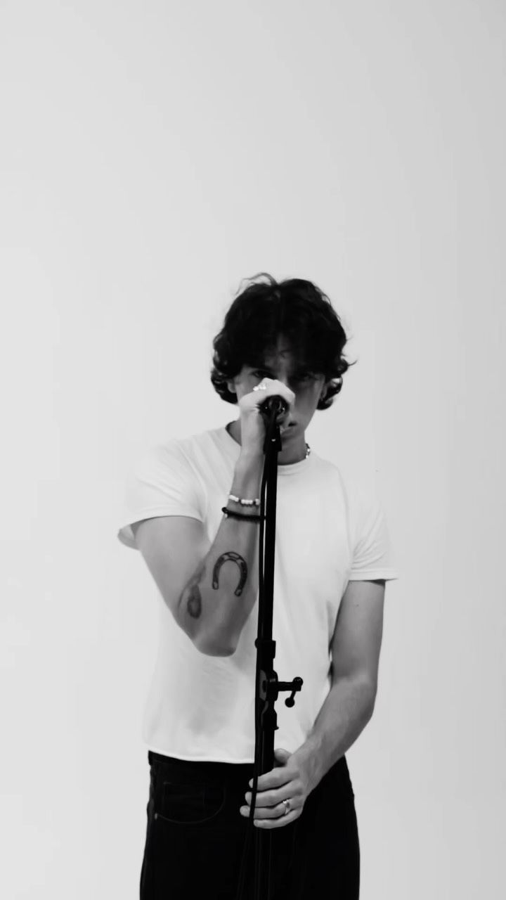 Black and white portrait of Addison Inniss singing into a microphone