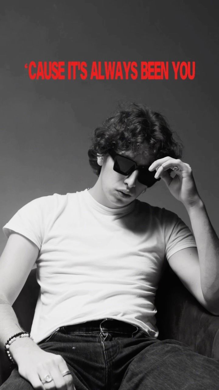 Addison Inniss in sunglasses, seated, in black and white
